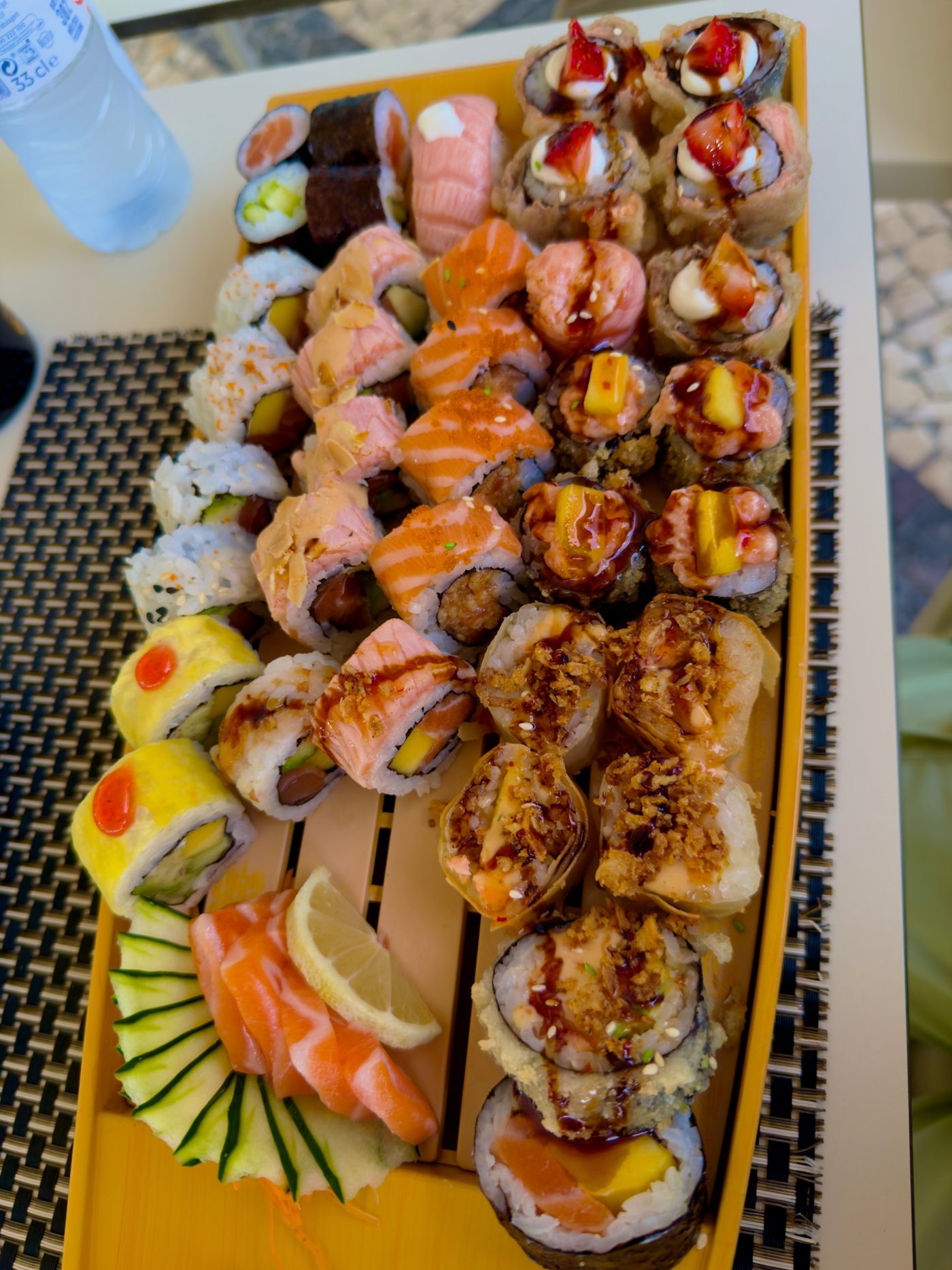 A boat of sushi rolls and salmon sashimi